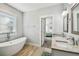 Bathroom with a soaking tub, granite vanity, and an open doorway to a bedroom, designed for relaxation at 7403 S Obrien St, Tampa, FL 33616