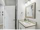 Clean bathroom featuring a white vanity with a marble countertop, modern fixtures, and a decorative mirror for added style at 7403 S Obrien St, Tampa, FL 33616