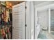 Hallway view into a bathroom with a white vanity, matching framed artwork, and a nearby closet filled with clothing at 7403 S Obrien St, Tampa, FL 33616