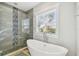 Bathroom featuring a soaking tub under a window and a tiled glass shower, offering a spa-like experience at 7403 S Obrien St, Tampa, FL 33616