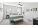 Well-lit bedroom with two windows, ceiling fan, and a neatly made bed with a bench at 7403 S Obrien St, Tampa, FL 33616