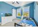 Bright blue bedroom with natural light from two windows and comfortable furnishings at 7403 S Obrien St, Tampa, FL 33616