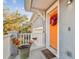 Close-up of a bright orange front door adorned with a festive wreath, creating a warm and inviting entrance to the home at 7403 S Obrien St, Tampa, FL 33616