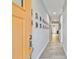 Inviting hallway with light wood floors, neutral walls decorated with framed Gathering photos, and a bright and open feel at 7403 S Obrien St, Tampa, FL 33616