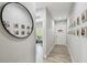 Bright hallway with wood-look tile flooring, a decorative mirror, and Gathering photos adorning the wall at 7403 S Obrien St, Tampa, FL 33616