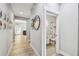 Hallway featuring wood-look tile floors leading to a bathroom with a white vanity and a shower with stylish tile accents at 7403 S Obrien St, Tampa, FL 33616