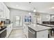 Bright kitchen with stainless steel appliances, white cabinetry, and a granite countertop island at 7403 S Obrien St, Tampa, FL 33616