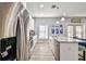 A well-lit kitchen features stainless steel appliances and a granite countertop kitchen island with seating at 7403 S Obrien St, Tampa, FL 33616
