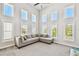 Bright living room features soaring ceilings, multiple windows, and comfortable gray sectional sofa at 7403 S Obrien St, Tampa, FL 33616