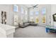 Spacious living room with tall windows, a comfortable sectional sofa, and built-in shelving showcasing natural light at 7403 S Obrien St, Tampa, FL 33616