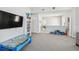 Bright open living space with large TV, shelves, and a view of the upstairs area at 7403 S Obrien St, Tampa, FL 33616