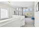 A loft area with large windows, a ceiling fan, and a view of the living area below at 7403 S Obrien St, Tampa, FL 33616
