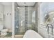 Tiled shower with a glass enclosure next to soaking tub under a window, creating a serene bathroom setting at 7403 S Obrien St, Tampa, FL 33616