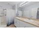 Bright bathroom featuring a double sink vanity with shower and tub featuring a shower curtain at 7497 W Lenox Cir, Punta Gorda, FL 33950