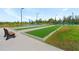 Scenic bocce ball courts surrounded by lush landscaping, benches and a walking path for leisure at 7497 W Lenox Cir, Punta Gorda, FL 33950