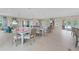 Spacious great room with dining tables, modern kitchen, comfortable seating and access to a pool area at 7497 W Lenox Cir, Punta Gorda, FL 33950