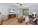 Cozy living room with a large TV, ceiling fan, and sliding doors that offer access to the outdoor patio at 7497 W Lenox Cir, Punta Gorda, FL 33950