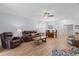 Open-plan living room with a ceiling fan, leather furniture, and dining area for flexible entertaining at 7497 W Lenox Cir, Punta Gorda, FL 33950