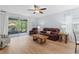 Comfortable living room with a leather sofa set, ceiling fan, and sliding glass doors to an outdoor patio at 7497 W Lenox Cir, Punta Gorda, FL 33950