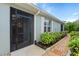 Exterior view featuring a screened-in entry, well-kept garden bed and pathway at 7497 W Lenox Cir, Punta Gorda, FL 33950