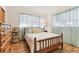 Bedroom featuring light blue sheer curtains, a wood bed and light colored walls at 8013 Cardinal Dr, Tampa, FL 33617