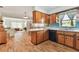 Traditional kitchen with wood cabinets and black appliances overlooking an open living area at 8013 Cardinal Dr, Tampa, FL 33617