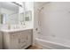 Bathroom with vanity sink, white tiled shower-tub combo and updated lighting at 846 Normandy Trace Rd, Tampa, FL 33602