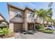 Two-story townhome featuring a one-car garage and lush tropical landscaping at 846 Normandy Trace Rd, Tampa, FL 33602