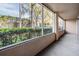 View of a screened patio with green shrubs lining the exterior and trees beyond at 846 Normandy Trace Rd, Tampa, FL 33602