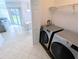 Modern front load washer and dryer next to dining area at 8517 Sea Harbour Ln # 103, Temple Terrace, FL 33637