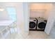 Modern front load washer and dryer next to dining area at 8517 Sea Harbour Ln # 103, Temple Terrace, FL 33637