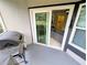 View of a patio with a sliding glass door to a room with gray sofa at 8517 Sea Harbour Ln # 103, Temple Terrace, FL 33637