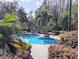 Inviting community pool surrounded by lush landscaping and swaying palm trees at 8517 Sea Harbour Ln # 103, Temple Terrace, FL 33637
