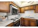 Cozy kitchen featuring white appliances, wood cabinetry, and white backsplash tiles at 9425 Blind Pass Rd # 506, St Pete Beach, FL 33706