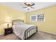 Inviting bedroom features a ceiling fan, natural light, and a comfortable bed with a side table at 952 Virginia St # 108, Dunedin, FL 34698