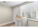 Entryway featuring tiled floors, a white storage cabinet, a window with blinds, and a white door at 952 Virginia St # 108, Dunedin, FL 34698
