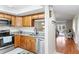 Bright kitchen featuring wood cabinetry, stainless steel appliances, and granite countertops at 952 Virginia St # 108, Dunedin, FL 34698