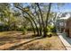 Spacious backyard with mature trees, lush landscaping, and screened in lanai at 9606 Braden Run, Bradenton, FL 34202