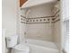 Cozy bathroom with tiled bathtub and shower, complemented by a mosaic-style accent for a unique touch at 9606 Braden Run, Bradenton, FL 34202