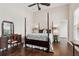 Bright bedroom boasts a four-poster bed, wood floors, and a classic vanity, blending comfort and style at 9606 Braden Run, Bradenton, FL 34202