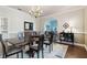 Elegant dining room with chandelier, dark wood table, and decorative rug, seamlessly flowing into the living space at 9606 Braden Run, Bradenton, FL 34202