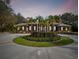 Stunning brick home boasts a circular driveway with lush palm trees and meticulously maintained landscaping at 9606 Braden Run, Bradenton, FL 34202