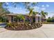 Beautiful brick home featuring an elegant entrance, palm trees, and a meticulously landscaped circular driveway at 9606 Braden Run, Bradenton, FL 34202