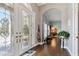 Bright and airy foyer with hardwood flooring, stained glass double doors, and a glimpse into the dining room at 9606 Braden Run, Bradenton, FL 34202