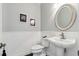 Elegant half-bath with pedestal sink, wainscoting and decorative mirror for a touch of sophistication at 9606 Braden Run, Bradenton, FL 34202