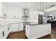 Bright, modern kitchen with white cabinets, stainless steel appliances, island, and stylish pendant lighting at 9606 Braden Run, Bradenton, FL 34202