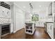 Spacious kitchen featuring white cabinets, stainless steel appliances, wine fridge, and a convenient center island at 9606 Braden Run, Bradenton, FL 34202