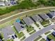 Aerial view of a new suburban neighborhood with modern homes, manicured lawns, and a scenic walking path at 9636 Channing Hill Dr, Ruskin, FL 33573