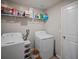 Convenient laundry room with modern white washer and dryer and ample shelving for storage solutions at 9636 Channing Hill Dr, Ruskin, FL 33573