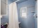 Clean bathroom showcasing blue tiling, a shower with a curtain, and a window at 10373 54Th N Ave, St Petersburg, FL 33708